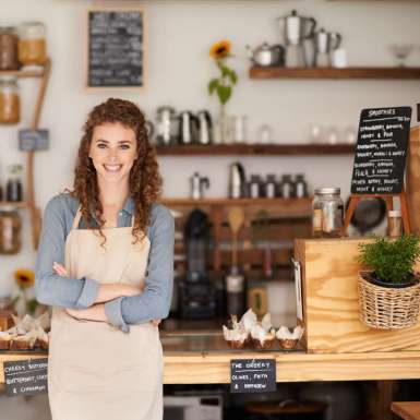 Portrait of an attractive young barista standing at a cafe counter